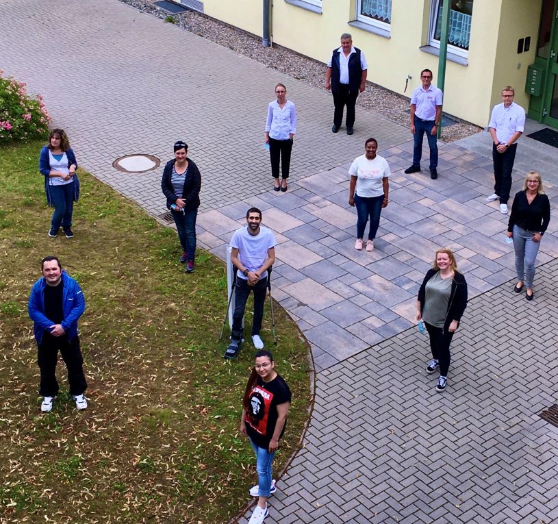 die Absolventen und Absolventinnen des Ausbildungskurses Pflegeassistent/-in sind von oben fotografiert zu sehen