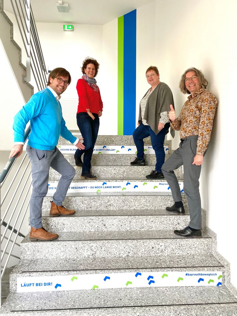 Treppenhaus im RW21 Stadtbibliothek und vhs Bayreuth (von links): Melanie Vogt (stellvertretende Leitung vhs Bayreuth), Martin Boeckstiegel (Leitung vhs Bayreuth), Heike Ender (stellvertretende Leitung RW21 Stadtbibliothek Bayreuth), Jörg Weinreich (Leitung RW21 Stadtbibliothek Bayreuth). © VHS Bayreuth
