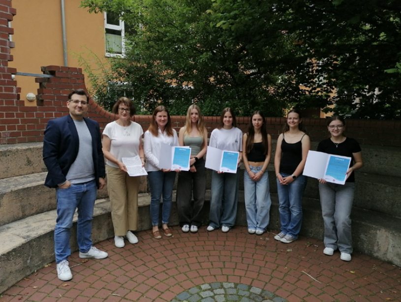Thomas Helminger (links) vom Fachdienst für Prävention und Gesundheitsförderung am Landratsamt Bayreuth übergibt die Urkunden an Studiendirektorin Sabine Fröber, Mitarbeiterin der RWG-Schulleitung, und die Vertreterinnen der Gewinnerklassen. © Landkreis Bayreuth